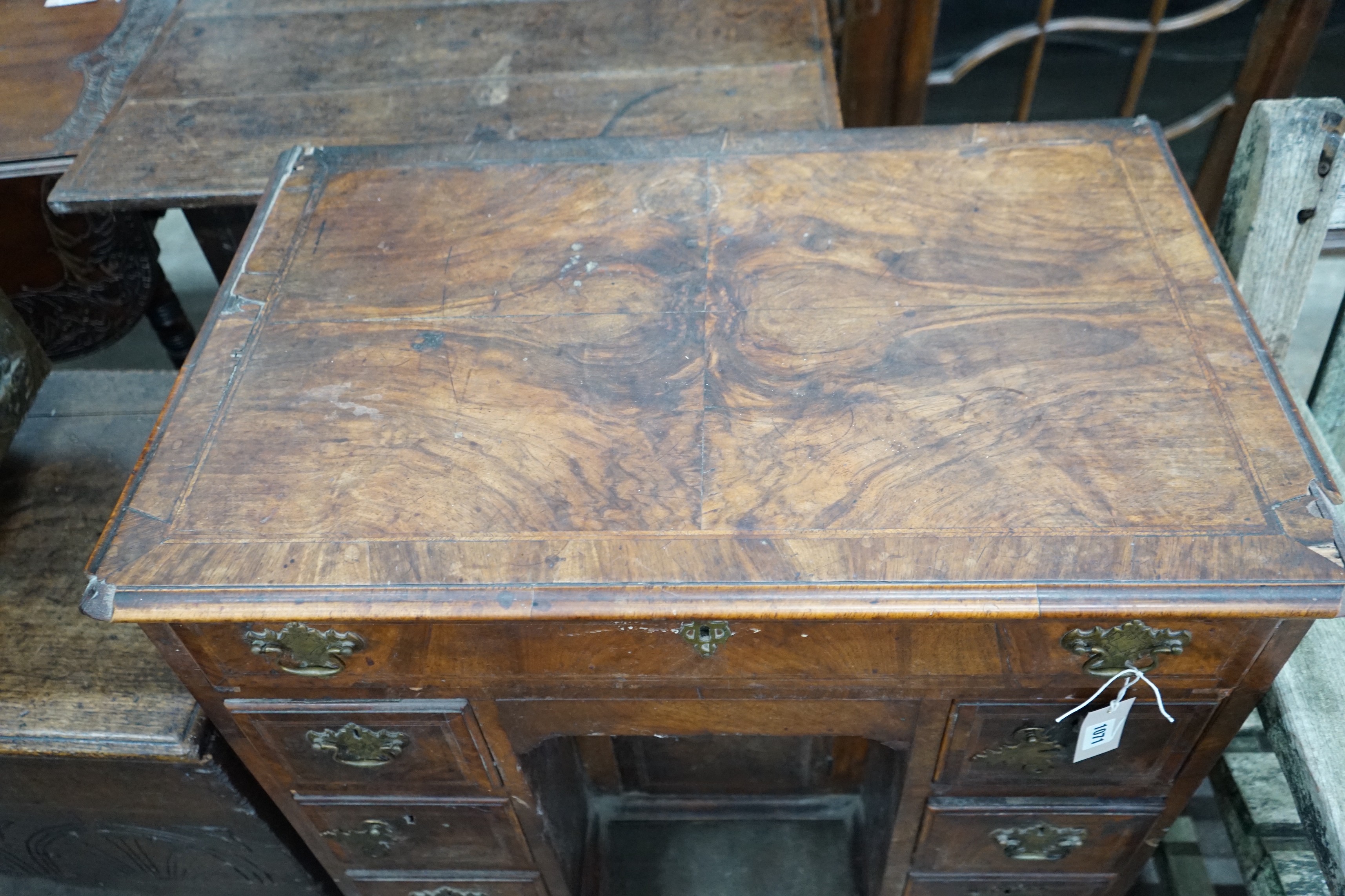 An 18th century feather banded walnut kneehole desk, width 81cms, depth 52cms, height 76cms.